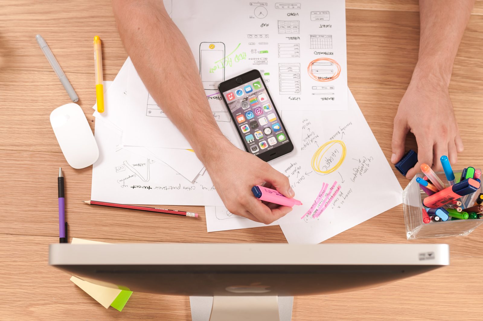 App workflow sketches and a phone on a work table